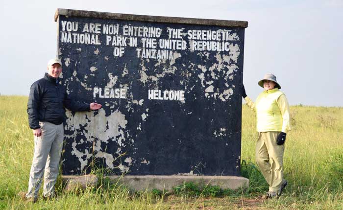 Danielle and husband with sign in Tanzania