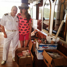 Sarah with a crew member and boxes of supplies
