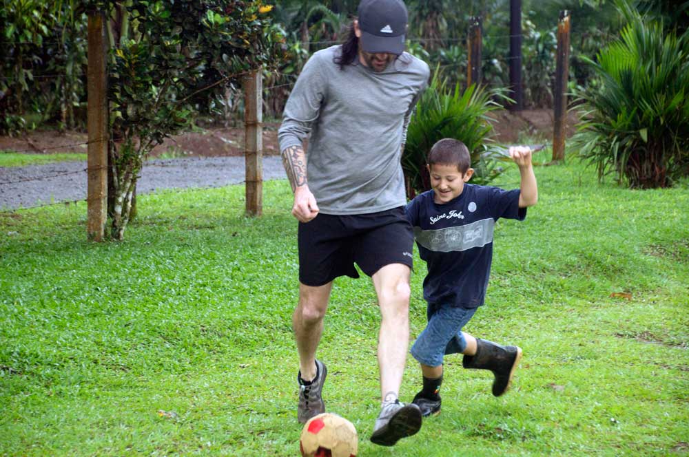 John's son playing soccer with the schoolchildren 
