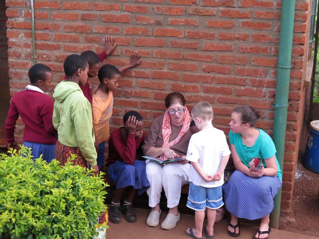 Reading a story to children at the children's home and other children staying at the tented camp